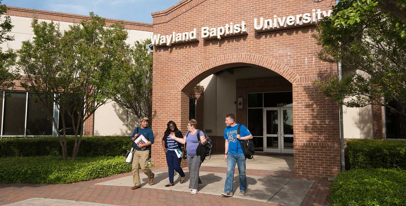 Adult learners talk amongst themselves as they exit a Wayland campus building